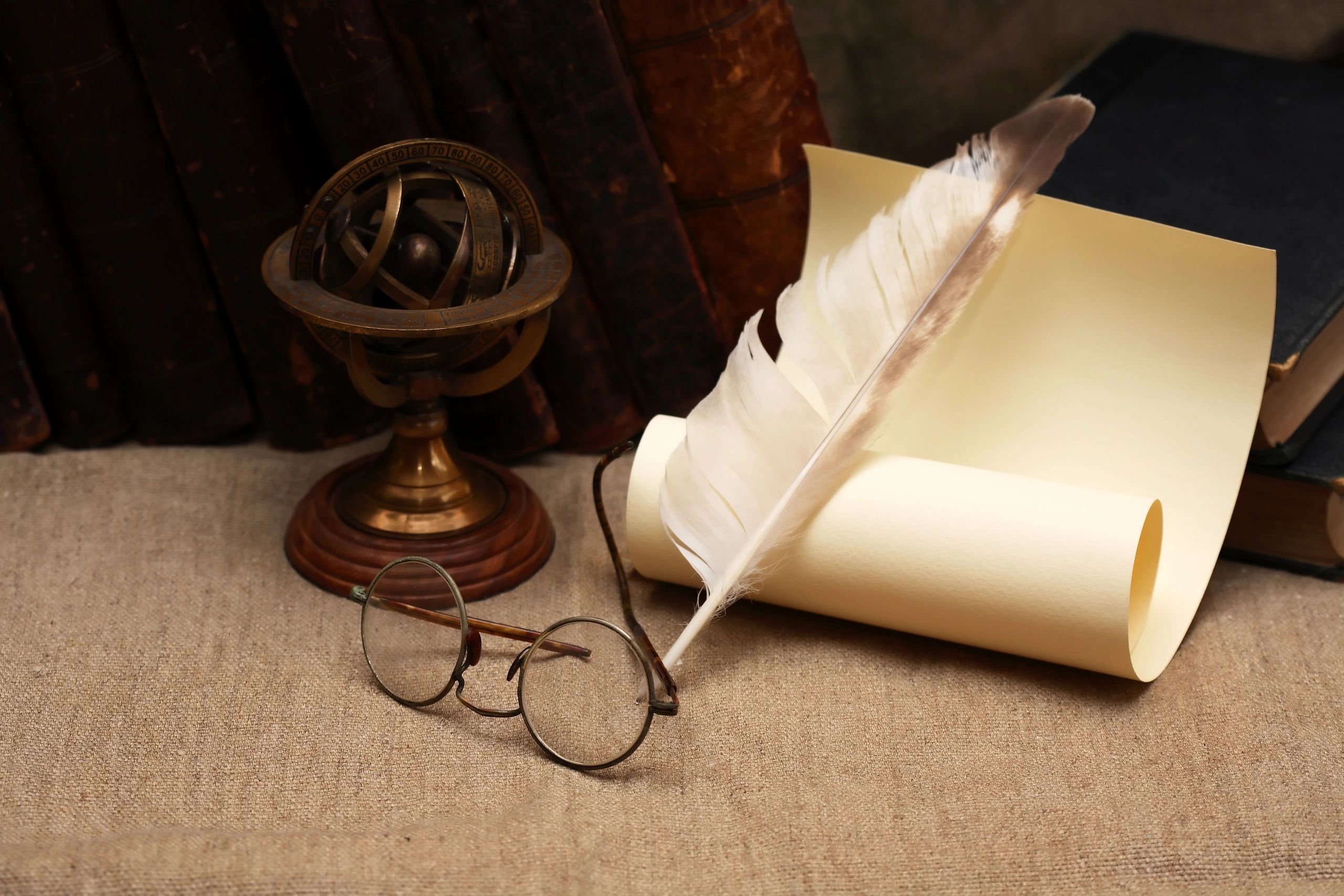 Vintage still life with books, quill pen, and old glasses