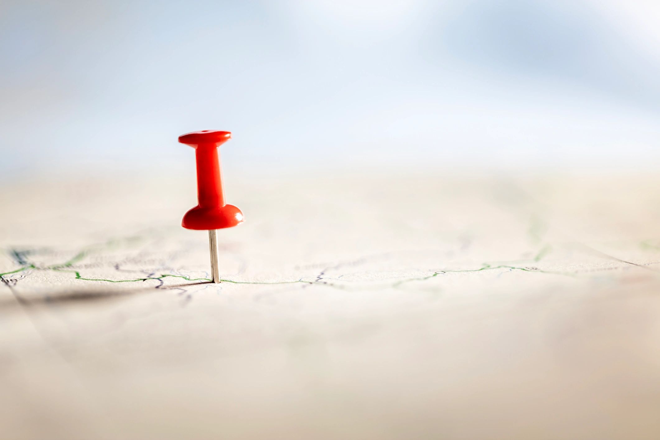 Red thumbtack marking a route on a road map