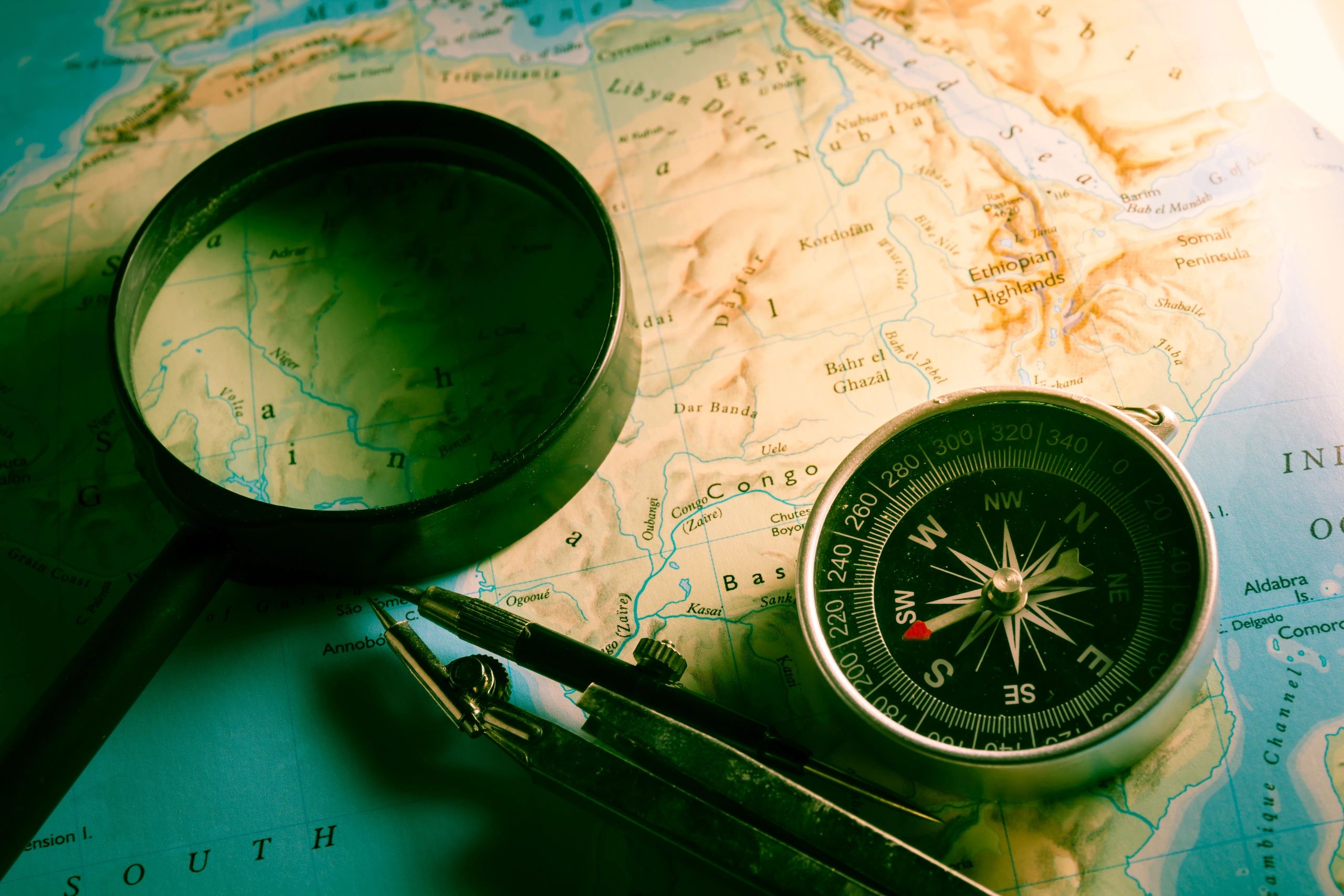 Compass and magnifier resting on a vintage map